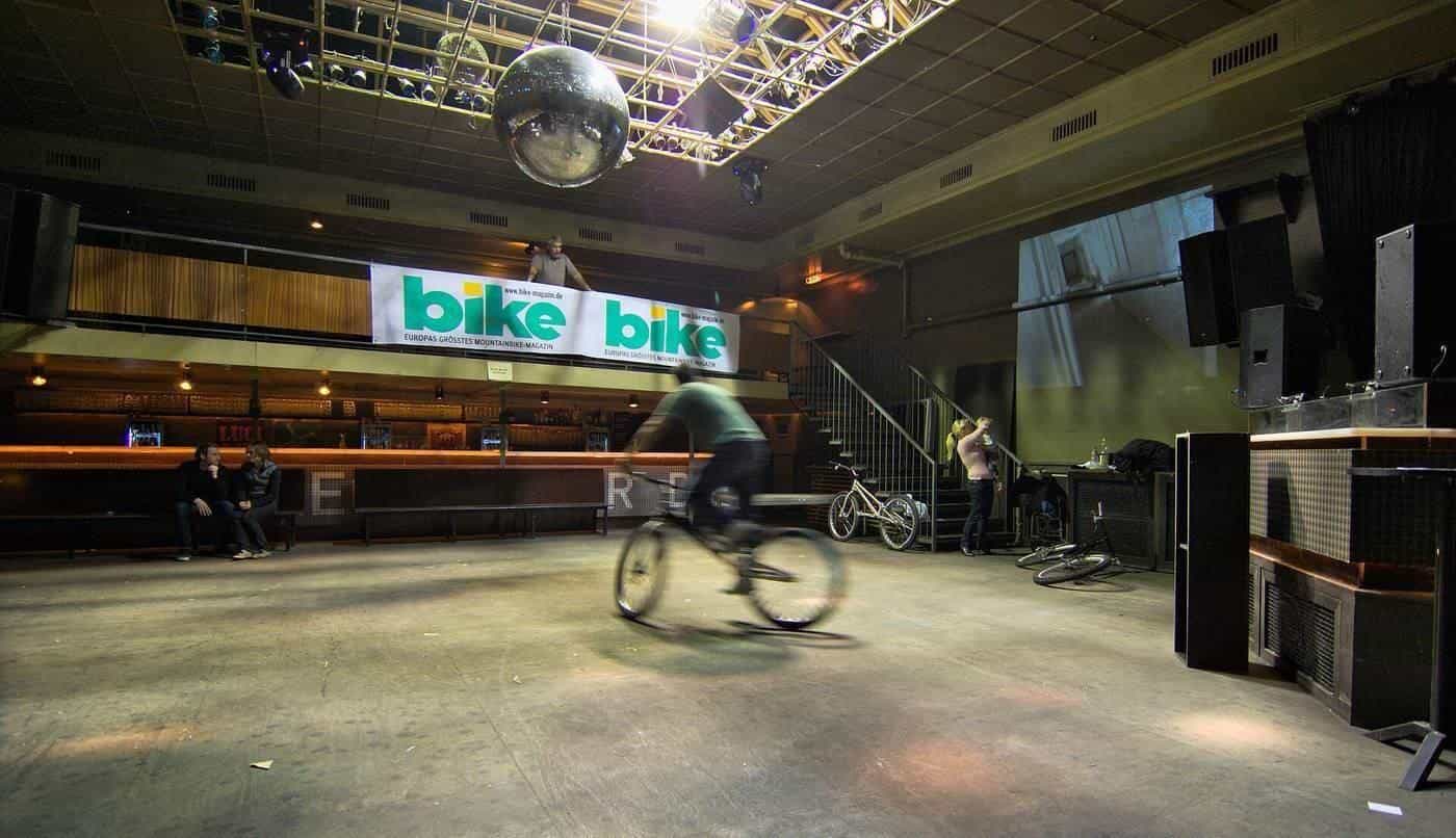 A large, empty nightclub hall with a smooth concrete floor